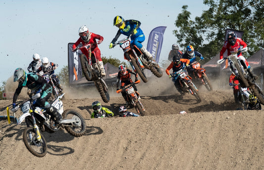 man in blue and yellow jacket riding motocross dirt bike