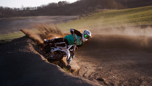 man riding motocross dirt bike on dirt road during daytime